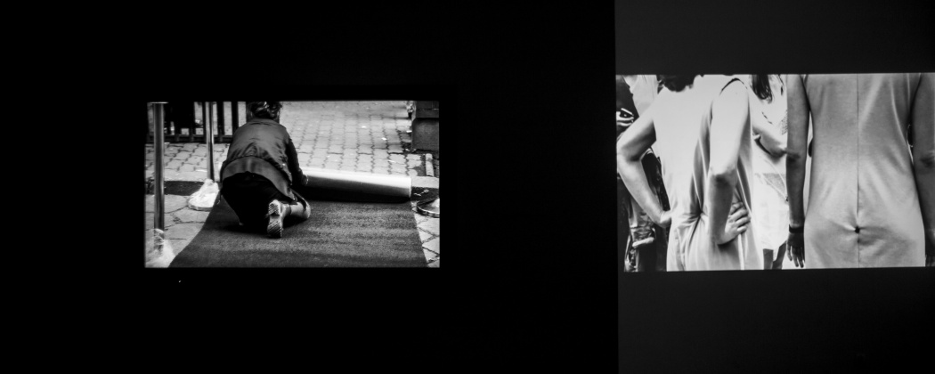 Dwie poziome fotografie umieszczone obok siebie na czarnym tle. Fotografia po prawej stronie przedstawia siedzącą tyłem kobietę w trakcie rozwijania dywanu. Druga fotografia po prawej stronie przedstawia dwie kobiety w jasnych sukienkach stojące tyłem. Kadr obejmuje ich sylwetki od pasa po ramiona.